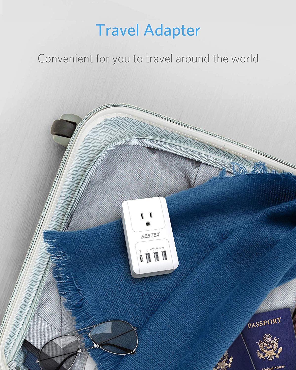 BESTEK travel plug adapter — adapter packed beside a passport and travel bag